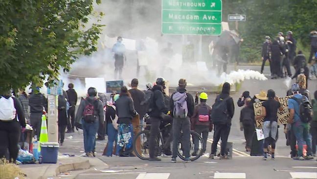 A tear gas canister flies through the air near a group of protesters near the ICE facility in South Portland on Saturday, June 14, 2025. Portland police declared the gathering a riot. (KATU)